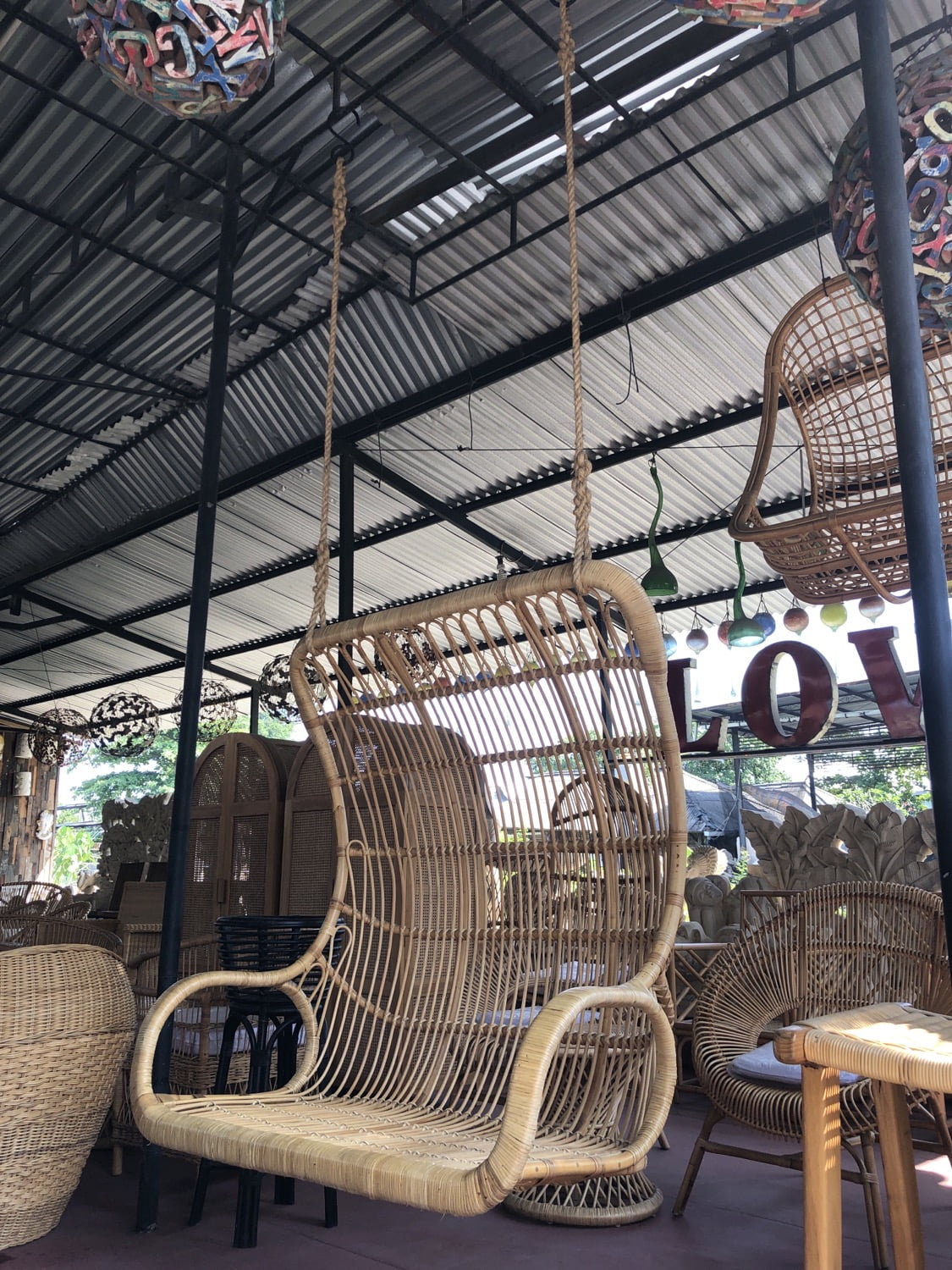 Hanging chair in wooden leather, with a large cushion and a rope